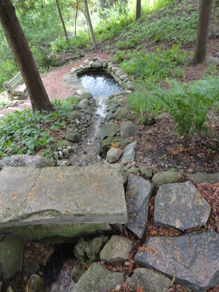 Step across this big flat rock across the hillside spillway which filters into the pond below...