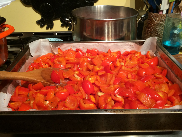 12 red peppers and all the garlic in the kitchen ready to roast
